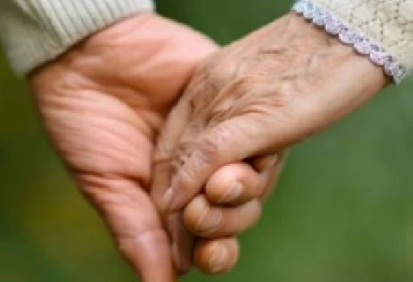 Close-up of two elderly hands holding each other gently, representing love, support, and togetherness.